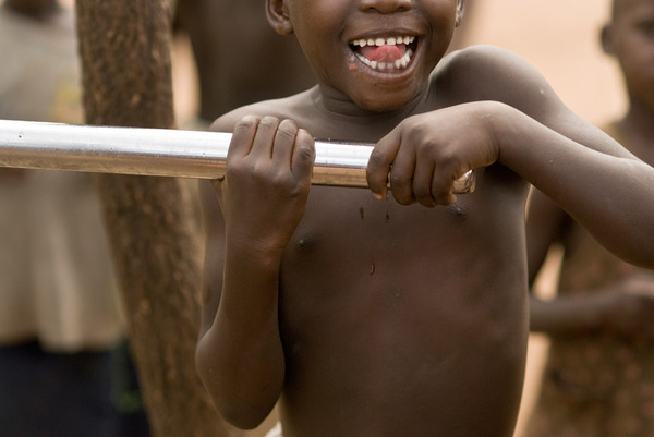 a boy in bobi, uganda pumps water from one of our first wells. www.charitywater.org