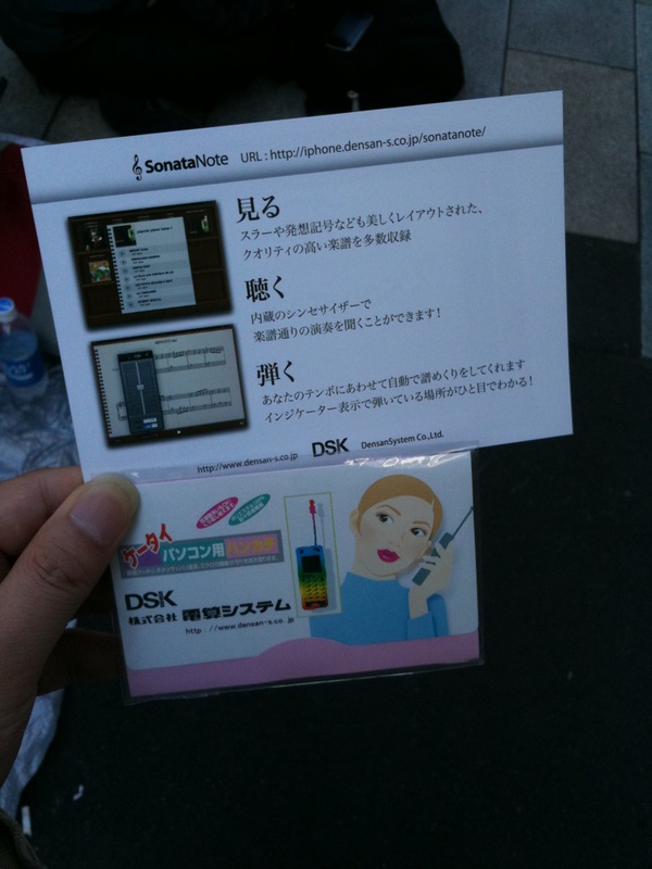 銀座でiPadの発売を待つ人にアプリケーション開発会社の人が携帯向けクリーニングクロスをプレゼントしています(編集k