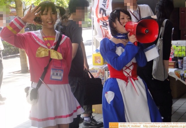 PC-DIY EXPOで大阪・日本橋のキャラ音々ちゃん光ちゃんのコスプレをした人が音々ちゃん光ちゃんグッズをアピール中。「秋葉原のみなさーん！」と拡声器で話しかけている。