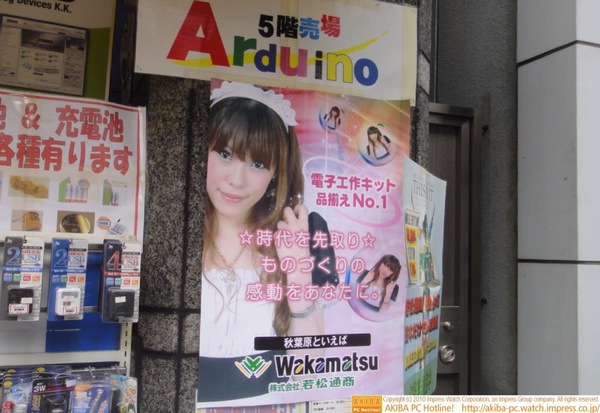 若松通商の店頭にメイドの写真を使ったポスターあり。「電子工作キットNo.1 ☆時代を先取り☆ものづくりの感度をあなたに。秋葉原といえば若松通商」
