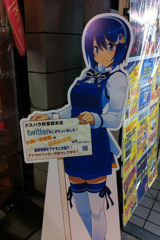 ドスパラ本店の窓辺ななみは同店のTwitter開始をアピール中。特にショップオリジナルのアクセサリーは身につけていない。