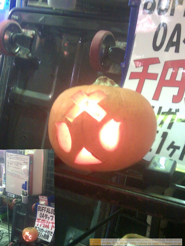 ソフマップ中古パソコン2号店に小さなハロウィンかぼちゃランタンが設置された。豆電球で光っている。なぜかおでこの部分に×マークがあり、バッテリーケースにはRADEONのシールが。
