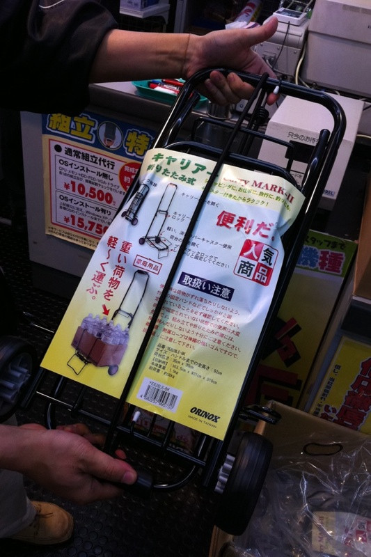 TSUKUMO ex.のスタッフが「新製品です！みんな大好き！」と言い張るアイテム。「荷物を置くフレーム部分にプラスチックのロック機構がついた」らしい。1000円。