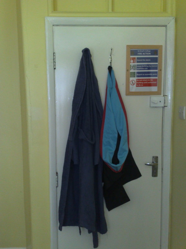 Dressing gown and academic hood hanging on door. Ah, college life.