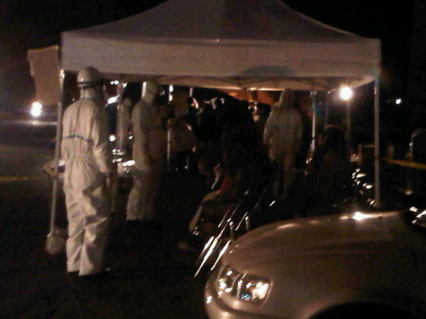 Japanese firemen in hazmat suits conduct tests on residents from near Fukushima reactor: