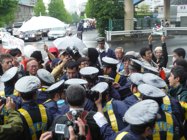 渋谷デモの逮捕までの流れ（その７）。おそらく、路上に倒されたデモ参加者の両手両足を警官がつかんで運ぼうとしているところです（浩） #57NONUKES 

