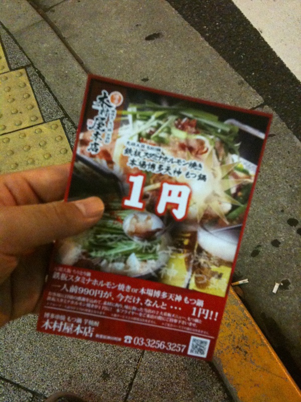 神田明神下の交差点でもつ鍋1人前1円のサービス券配付中。本来は990円らしい。