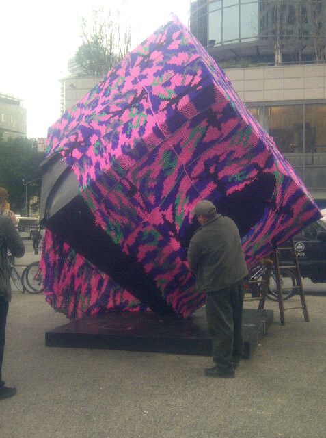 ...and now, minutes later, a guy is cutting it off..[Olek, new yarn bomb, Astor Place, NYC]