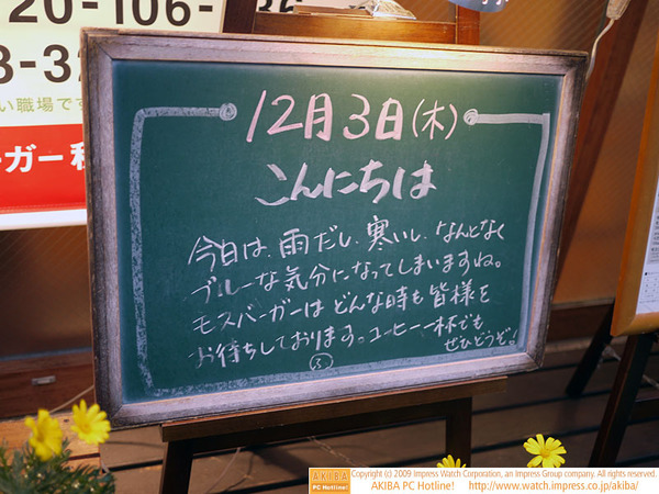 モスバーガー秋葉原末広町店の黒板 12/3 (木)昼版 - 「今日は雨だし、寒いし、なんとなくブルーな気分になってしまいますね。モスバーガーはどんな時も皆様をお待ちしております。」モス店員、仏の心境。