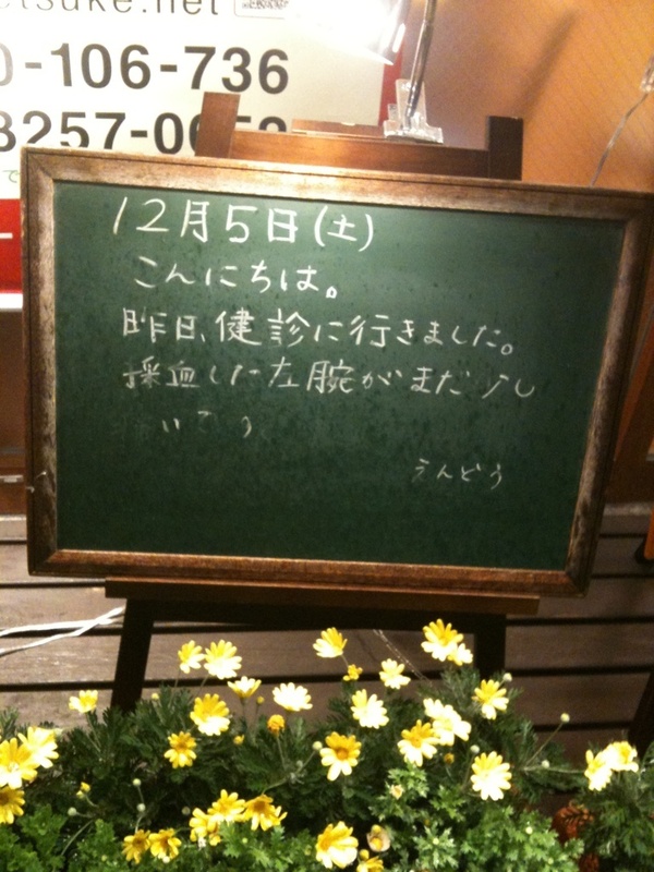 モスバーガー秋葉原末広町店の黒板 12/5(土)夜版 - 「昨日、健診に行きました。採血した左腕がまだ少し痛いです」モス店員、左腕を痛がる。