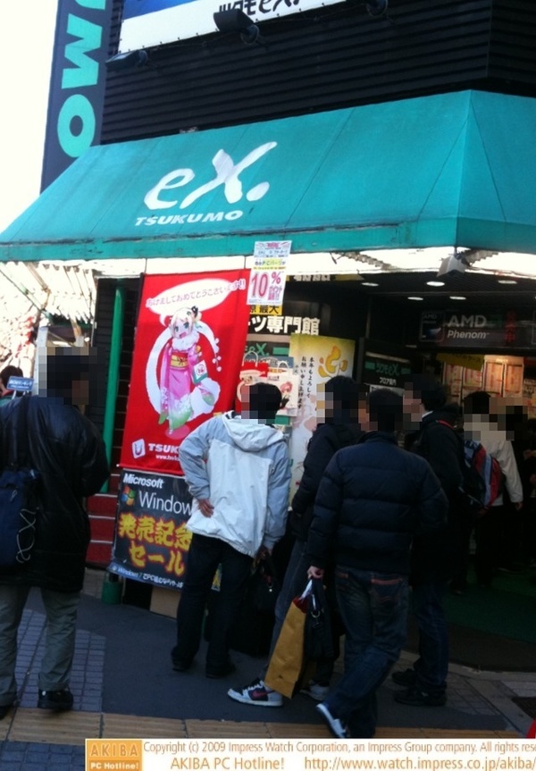 TSUKUMO eX.は玄関正面に、振袖バージョンのつくもたんを貼り出し、それをじっと見る人あり。