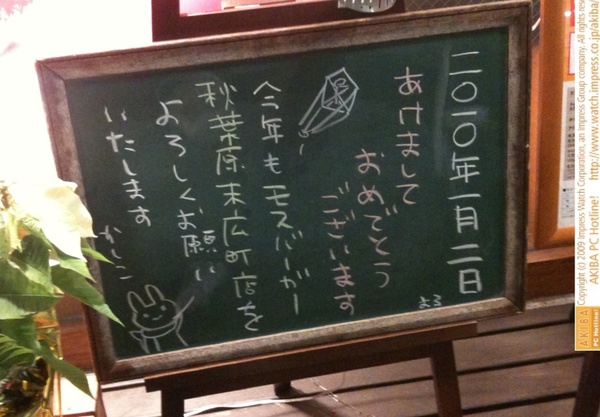モスバーガー秋葉原末広町店の黒板 1/2(土)夕版 - 「あけましておめでとうございます。今年もモスバーガー秋葉原末広町店をよろしくお願いいたします かしこ」モス店員、縦書きで新年挨拶。