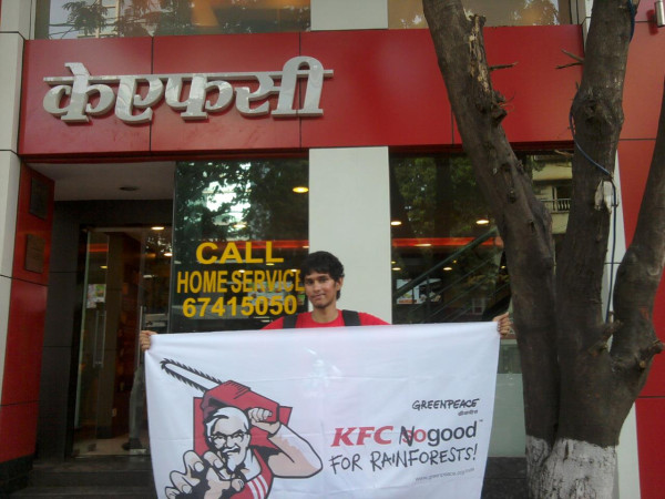 Greenpeace India volunteer take it to @KFC_India. A volunteer pulls out a banner in Mumbai. #KFCNoGood