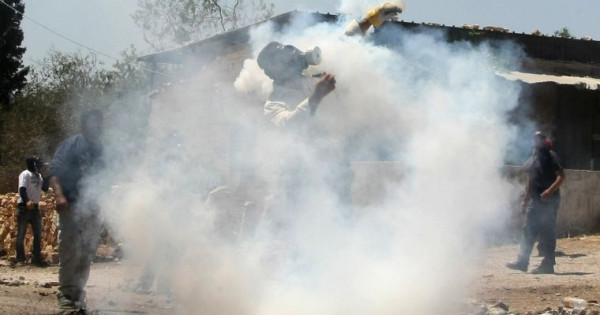 A Palestinian protester throws back a tear gas canister at Israeli soldiers during a #demonstration against the expropriation of Palestinian land by Israel near the West Bank city of #Nablus on June 1, 2012. 