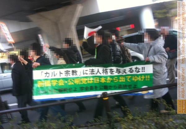 『「カルト宗教」法人格を与えるな!! 創価学会・公明党は日本から出てゆけ!!カルトに課税せよ 学会員を公職から追放せよ』秋葉原行進中のデモ隊プラカード。150人くらいいる。