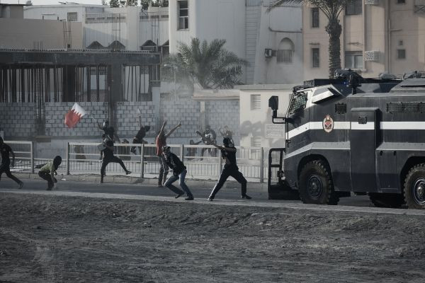 #Bahraini protestors hurl stones at a riot police vehicle during clashes following an anti-regime demonstration in the village of Jidhafs, west of #Manama on March 15, 2013. 
