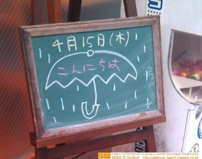 モスバーガー秋葉原末広町店の黒板4/15(木)昼版 - 「こんにちは」モス店員、傘イラストで挨拶。