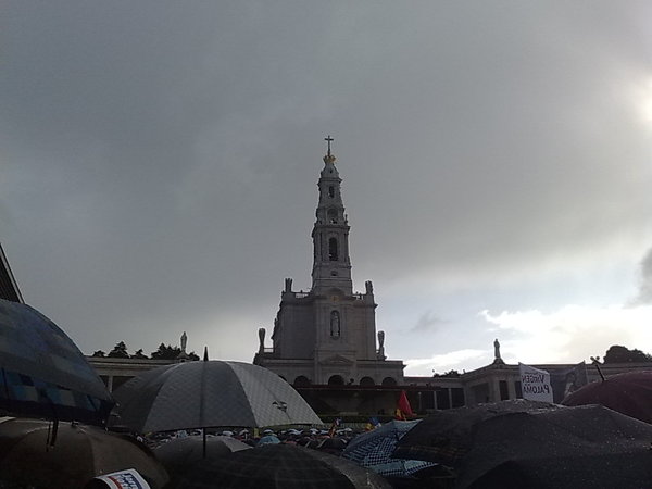 Chove neste momento torrencialmente em Fatima! Sao milhares de chapeus que cobrem o recinto!